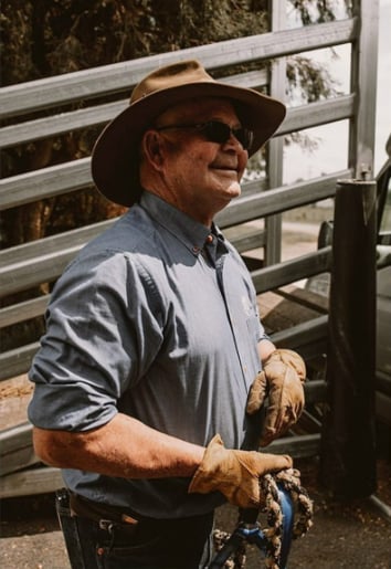 Smiling owner beside branded vehicle.